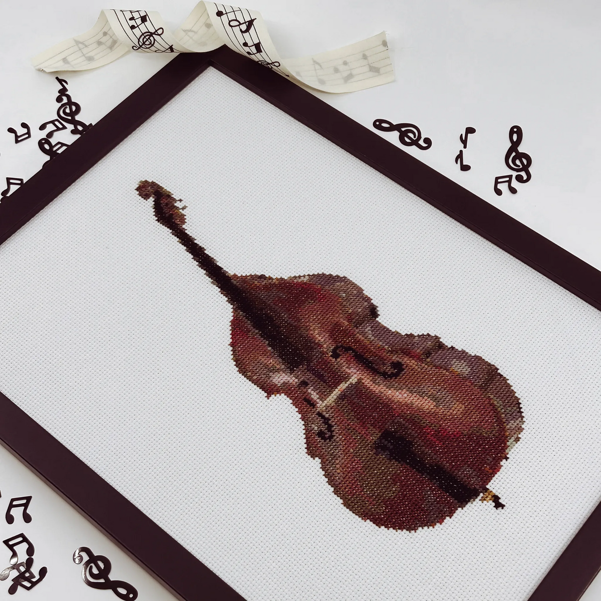 Cross stitch of a double bass on white fabric