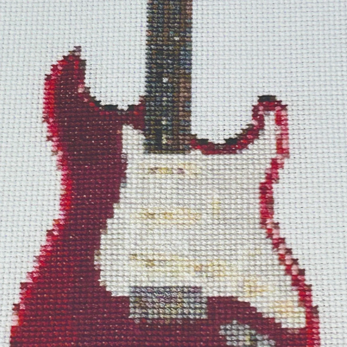 close up of the A4 print of the original embroidery design of a fender strat showing realistic stitches and fabric