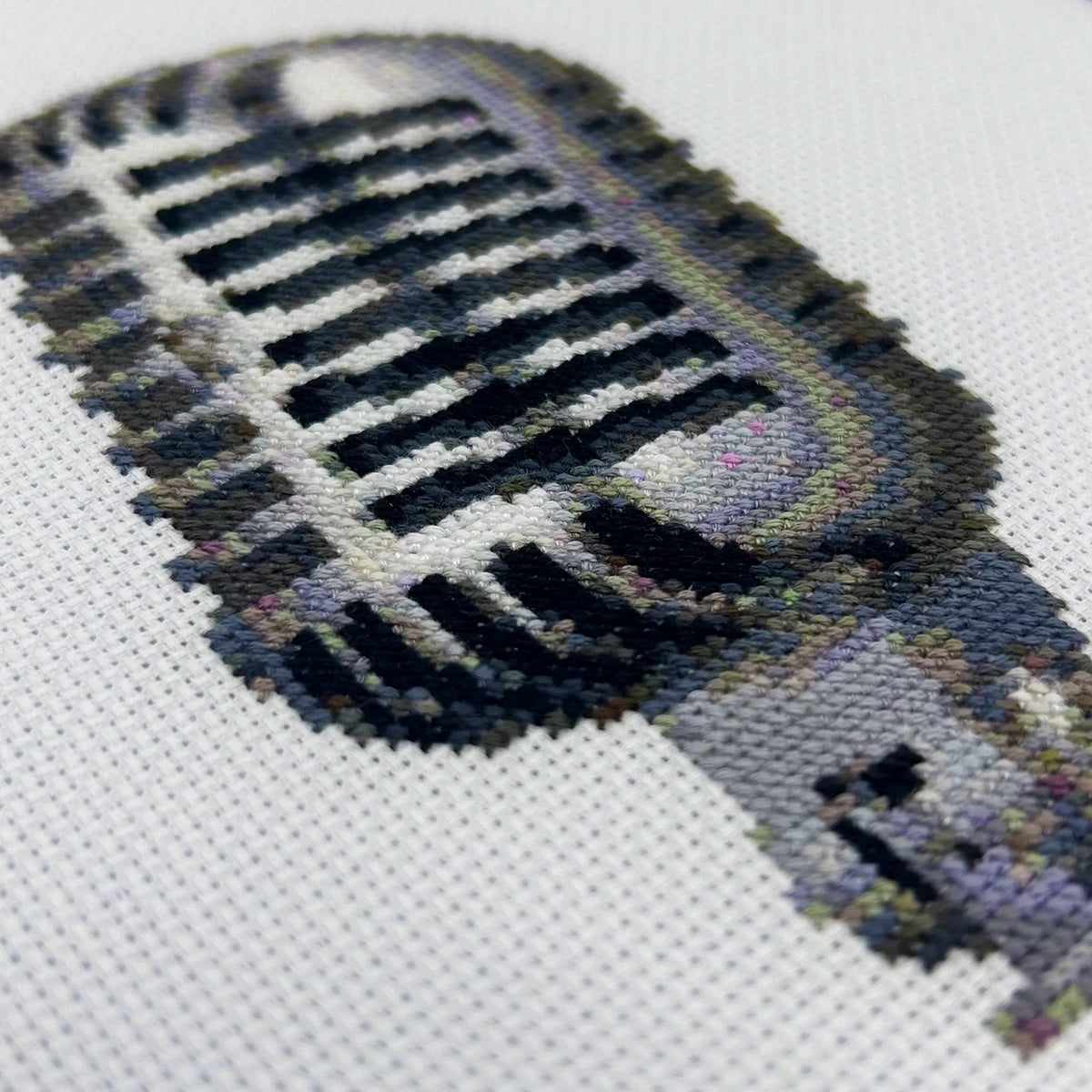 Close up of cross stitch retro mic on white aida fabric
