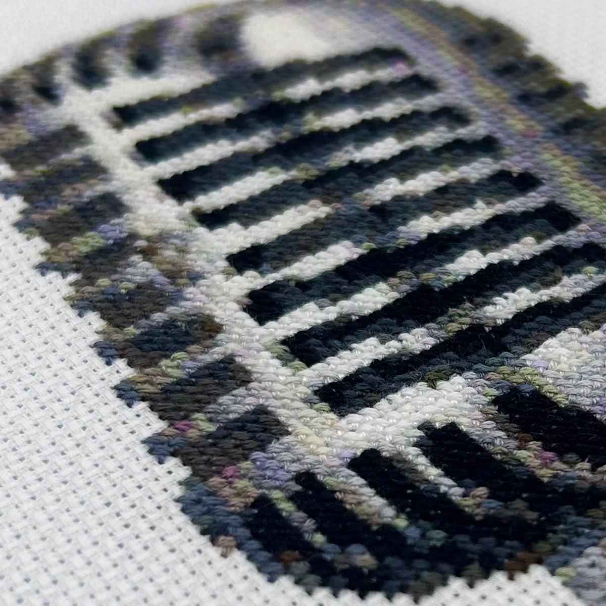 Close-up of a hand-stitched retro mic on white fabric