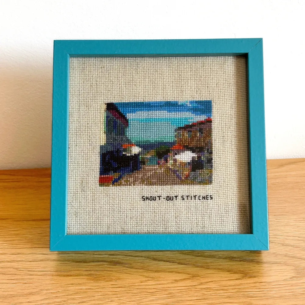 Close up of Illa de Ons cross-stitch piece in a blue square frame