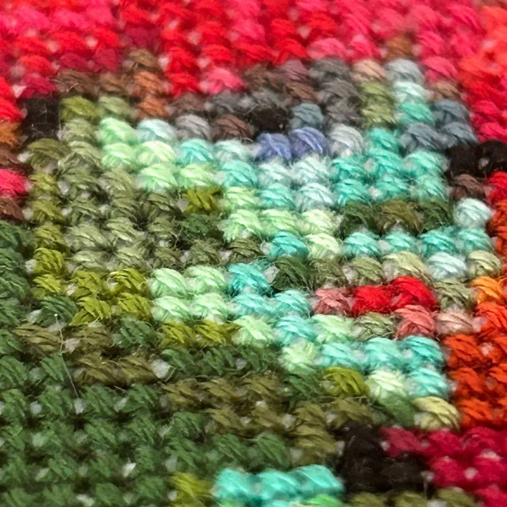 close up of the different coloured threads of the face and hair of Miss Argentina embroidery, from the film Beetlejuice