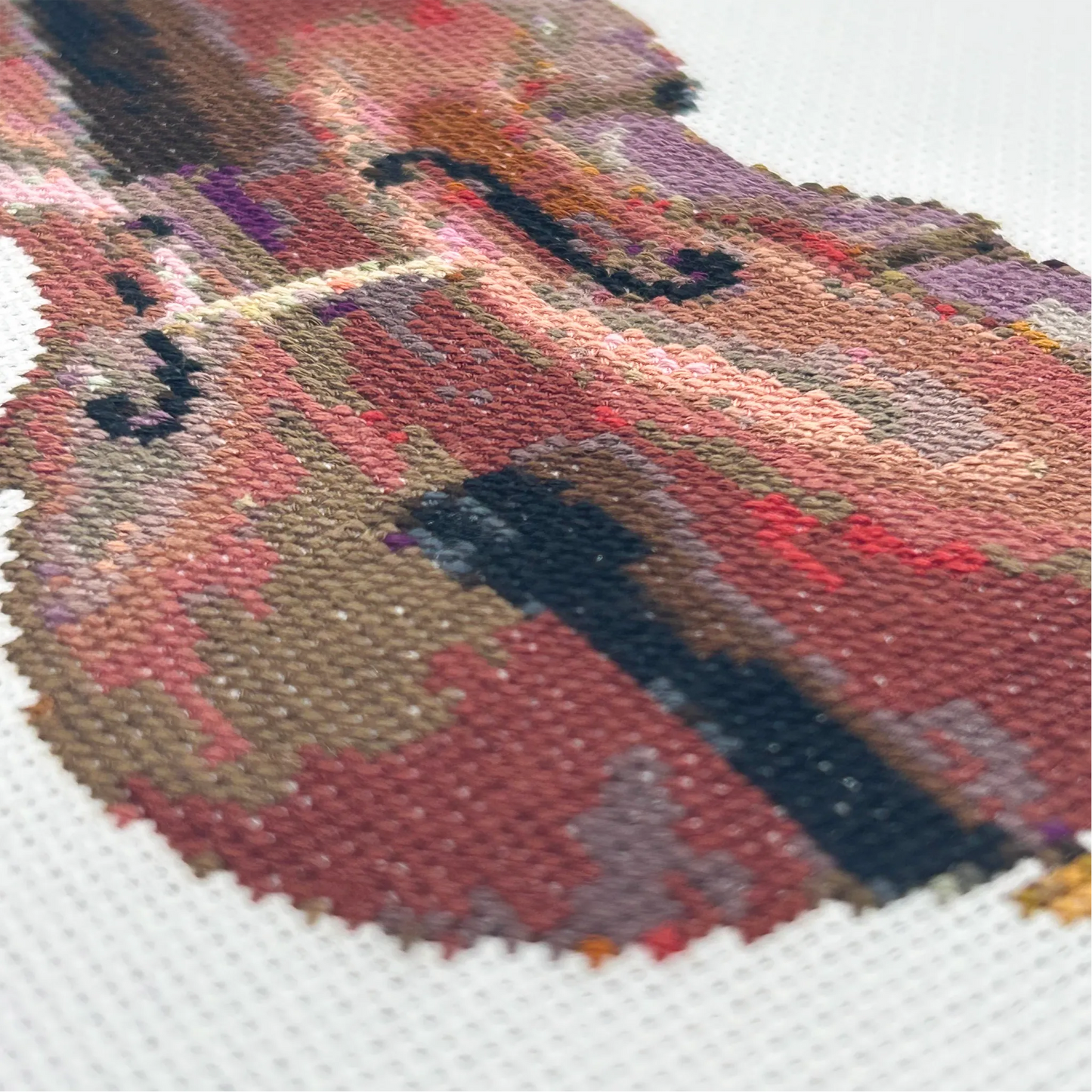 Close up of an embroidered double bass on white fabric