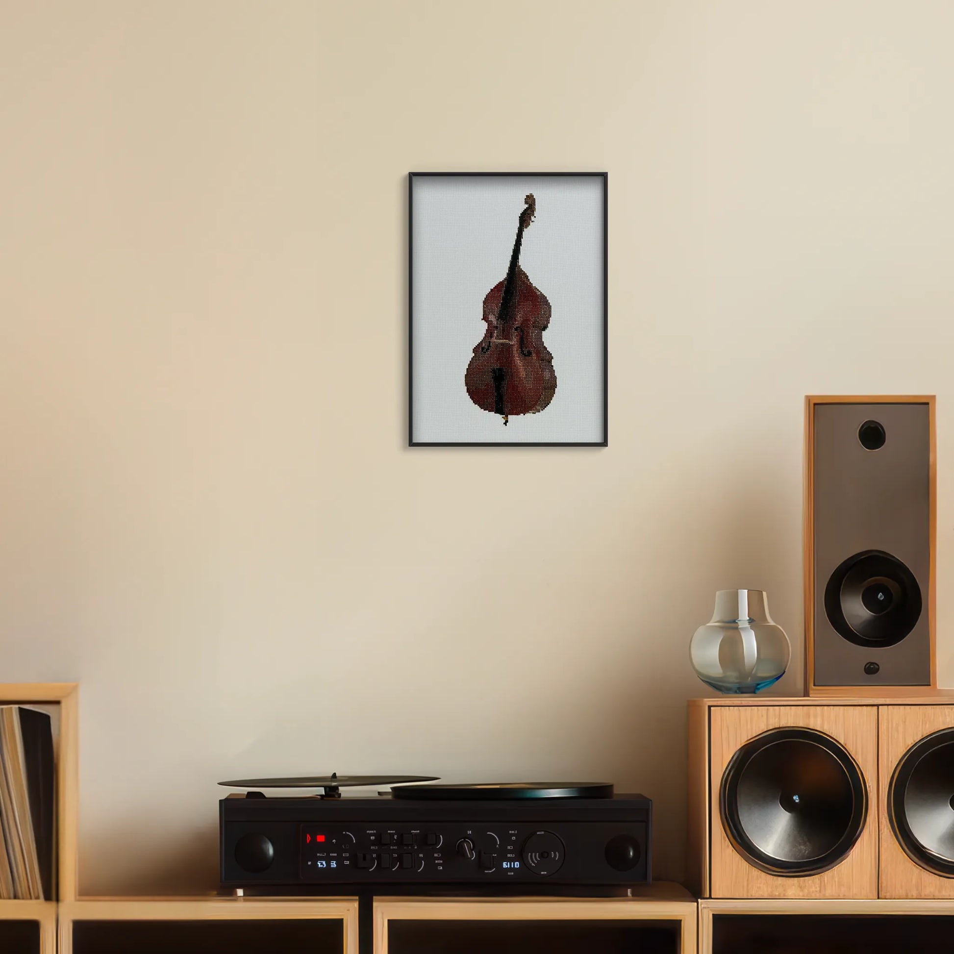 A4 print of the original embroidery design of a double bass framed and hung up on a wall above a record player
