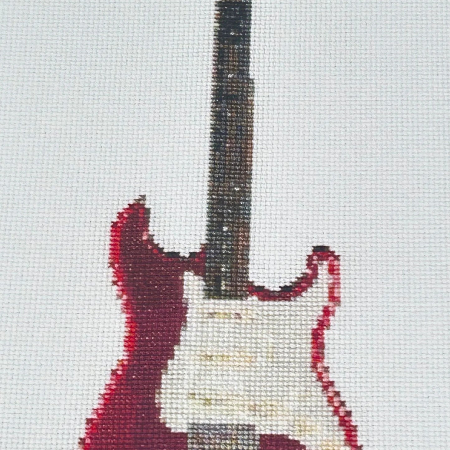 close up of the A5 print of a red fender strat original embroidery design showing realistic stitches and fabric