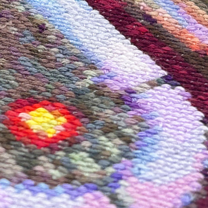 Extreme close up of the stitch details in a cross stitch piece of a retro jukebox