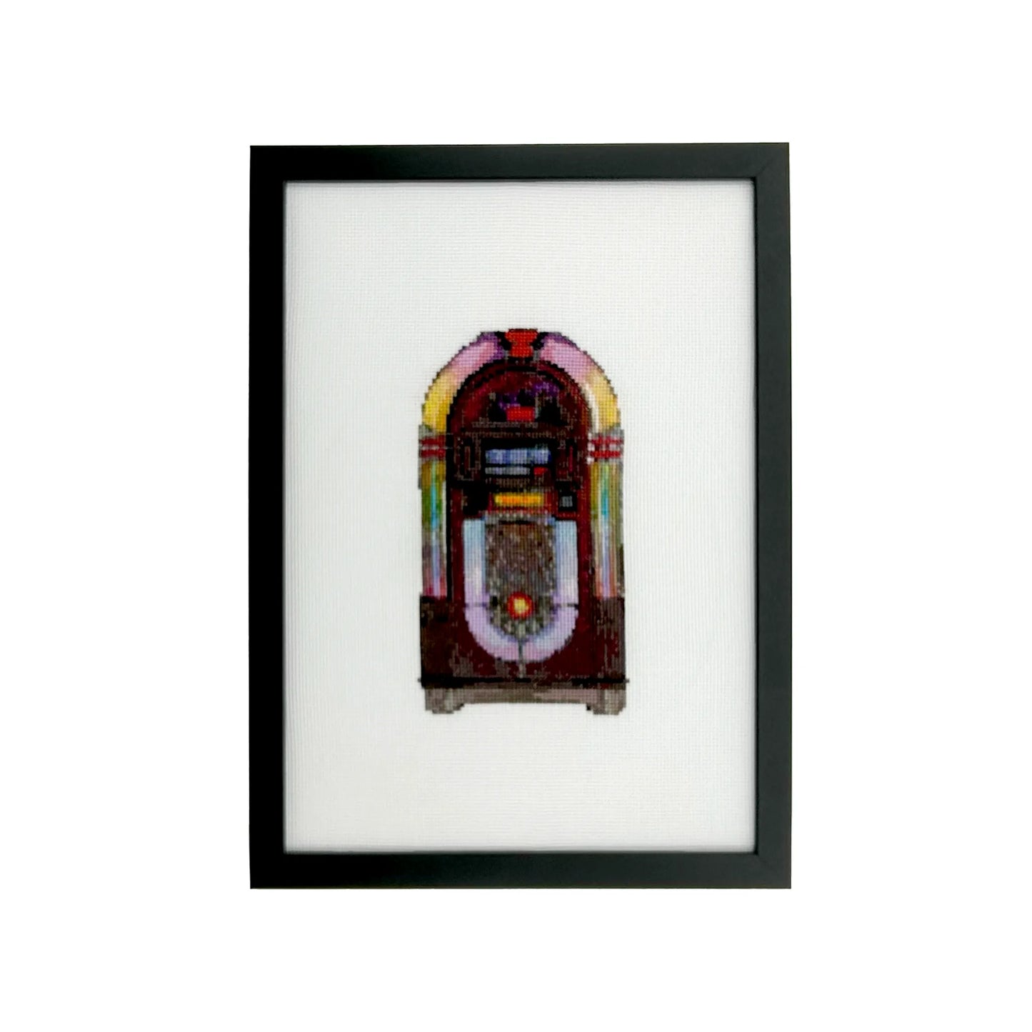 Framed cross stitch artwork of a vintage jukebox on white fabric