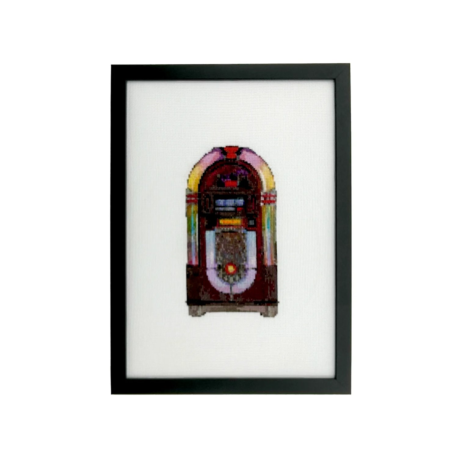 Framed cross stitch artwork of a vintage jukebox on white fabric