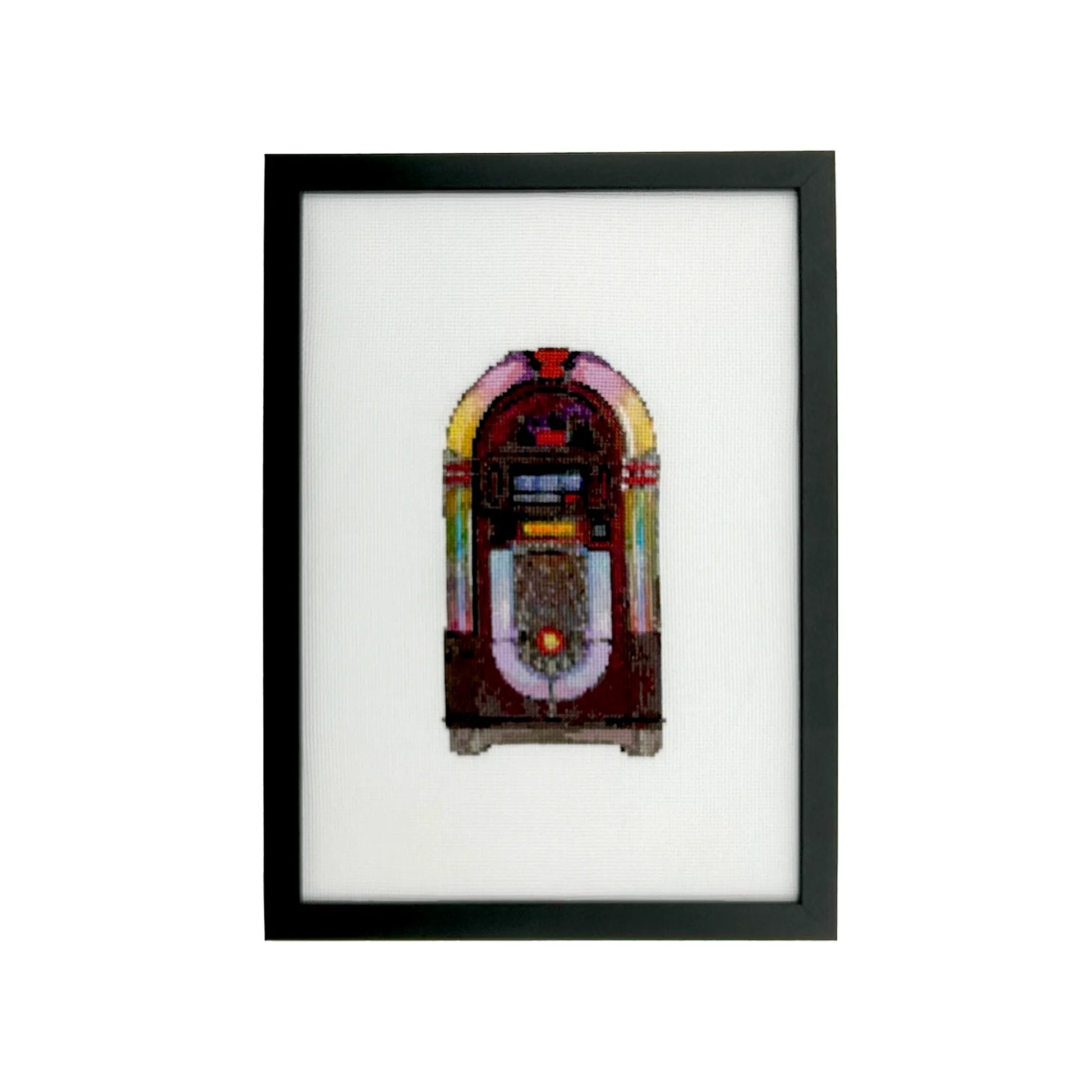 Framed cross stitch artwork of a vintage jukebox on white fabric