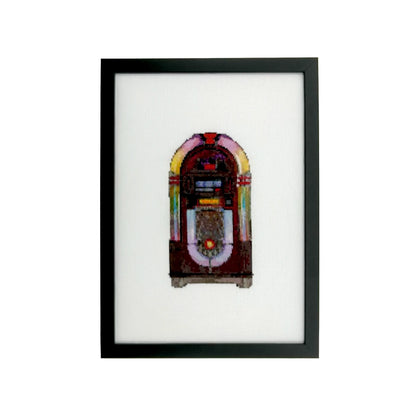 Framed cross stitch artwork of a vintage jukebox on white fabric