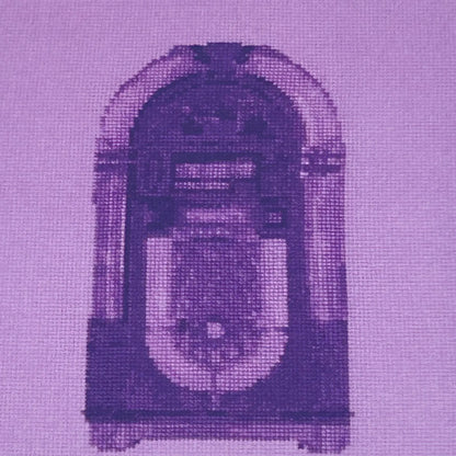 close up of the colourful postcard of the original embroidery design of a vintage jukebox