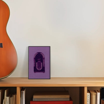 colourful postcard of the original embroidery design of a vintage jukebox framed and leaning against a wall on top of a desk next to a guitar