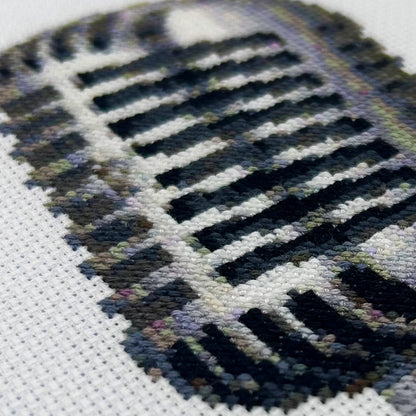 Close-up of a hand-stitched retro mic on white fabric