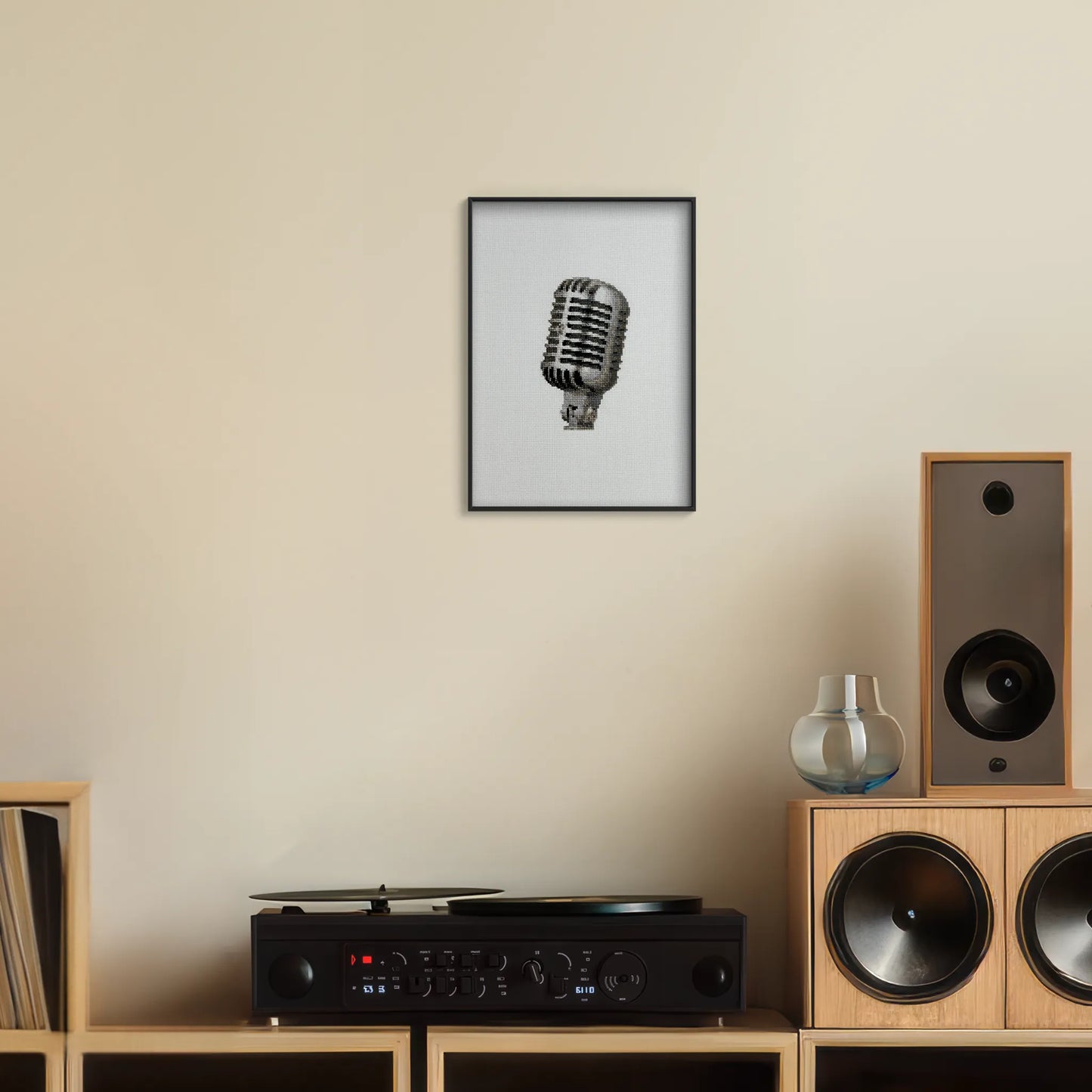 A4 print of the original embroidery design of a vintage mic framed and hung up on a wall above a record player