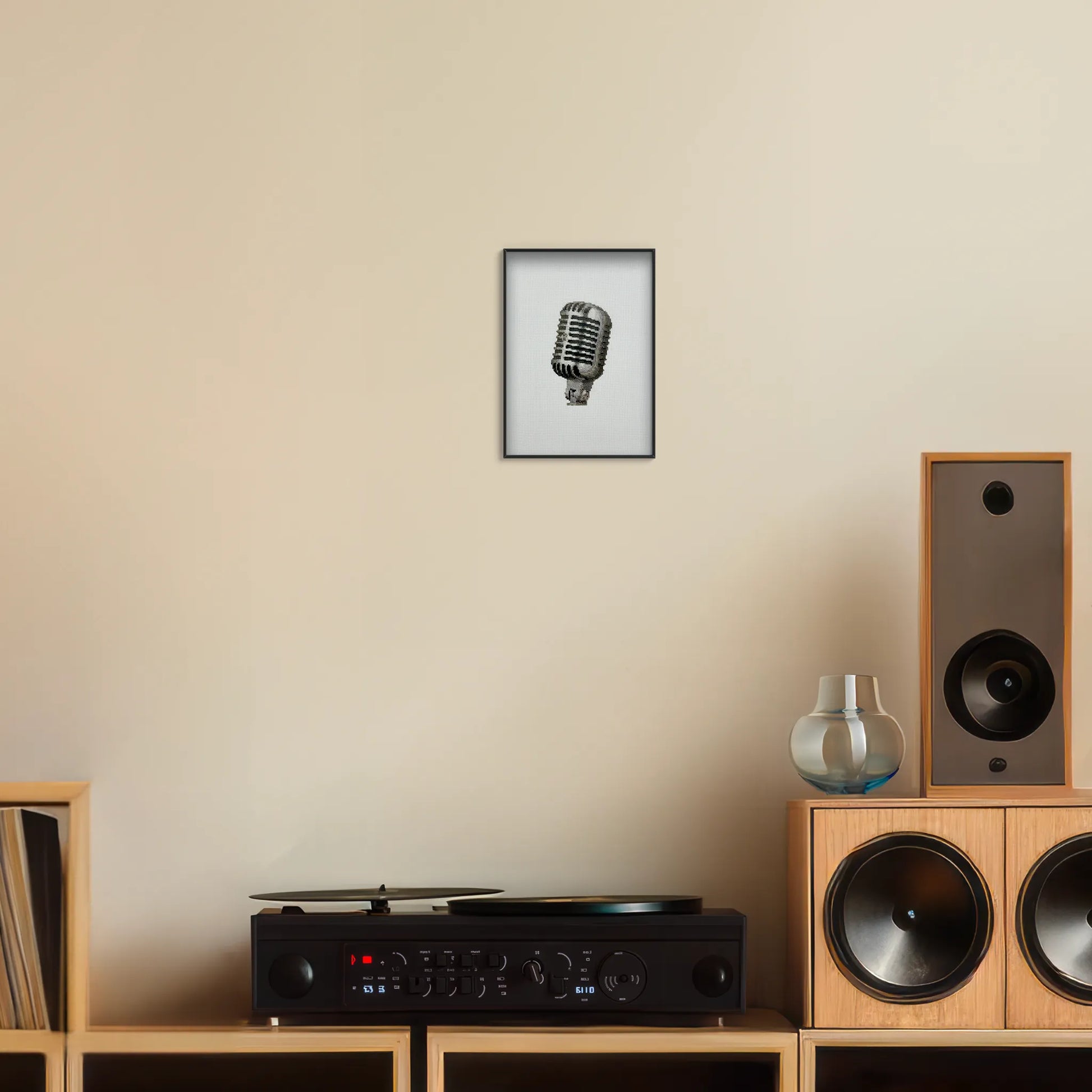 A5 print of the original embroidery design of a retro mic framed and hung up on a wall above a record player