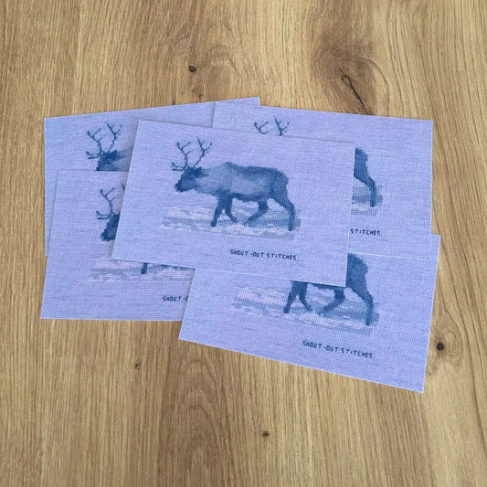 Reindeer in the snow embroidered print on a postcard in purple inverted colours.