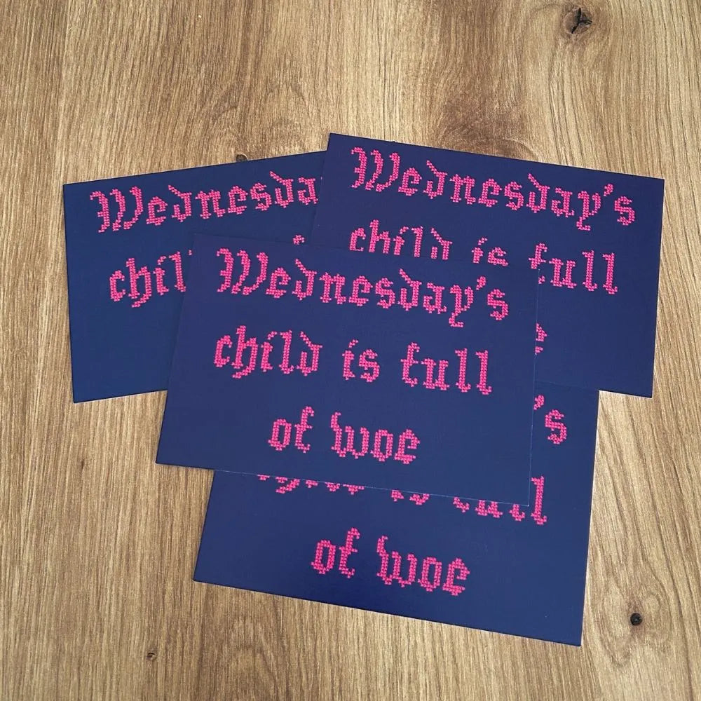 Wednesday's child is full of woe embroidered style postcard in inverted colours the text is pink on a black blueish background